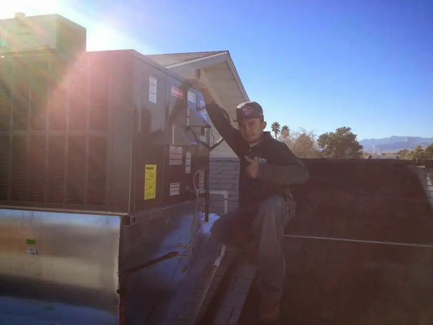 HVAC technician performing Heat Pump Repair on a rooftop unit in Lexington